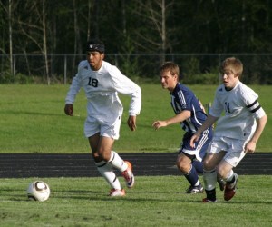 James Young (18) gets past Squalicum forward Josh Bramlett as Pat Myatt (14) moves inside for a shot on goal.