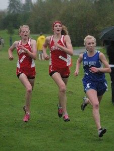 Lillianna Stelling sprints toward the finish to pass a duo of racers from Stanwood. Stelling finished 10th in the sophomore class race in 20 minutes