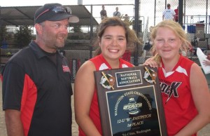 Alohi Elliot of Langley holds the championship plaque for the U-12 “B” softball tournament held in late June in the Tri-Cities. With her are head coach Scott Campbell and teammate Breanna Board.