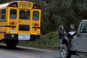 Onlookers survey the mangled hood of the Jeep Wrangler that rear-ended a South Whidbey school bus Thursday afternoon. No students were hurt and the driver was unharmed.