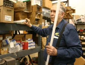 School district electrician Art Pratt shows the difference between older T-12 bulbs with energy efficient T-8s.