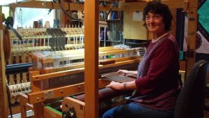 Linda LaMay weaves an alpaca and silk scarf on her 24-shaft AVL loom.