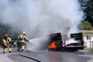 Firefighters work to put out the flames that fully engulfed a truck on Wednesday afternoon.