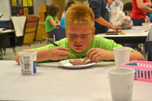 Fifth grade student Ashton McGee puts a coat of burnt orange on his colonial candlestick holder in Betsy Gmerek’s art class at South Whidbey Elementary School.