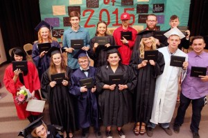 Graduates of South Whidbey Academy’s class of 2015 hold up their diploma covers after the commencement ceremony concluded Thursday