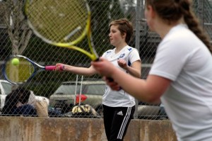 Falcon junior Tess Radisch returns a serve with a crosscourt forehand with teammate Amelia Weeks in the foreground.
