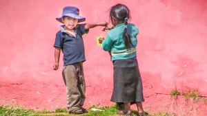 Two Mayan children pour clean water from a pump installed with the help of Rotary of South Whidbey