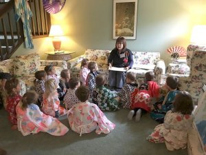 Mako Willett tells a traditional folk story of Japanese culture to kindergarten students during the Northwest Language Cultural Center Global Cultures Program. The activity was one of six sessions/stations that were offered over the course of three days.  At this storytelling session they are engaged in traditional folk stories of the Japanese culture. Students are wearing kimonos