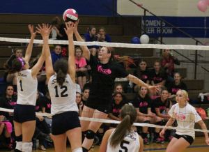 Falcon junior Anne Madsen tips over Sultan’s Devyn Jordan and Claudia Hubbard in the third set Tuesday night.
