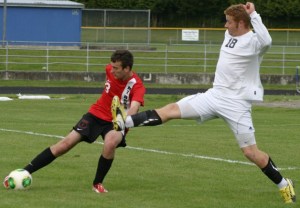 Falcon senior Sam Turpin high kicks to prevent Mount Baker senior Ruslan Zakurdayev from clearing the ball in the second half of the 1A District 1 playoff match Thursday. Turpin scored a goal earlier in the game which South Whidbey won