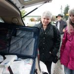 Kyle Jensen / The Record South Whidbey volunteers Marti Bauer (left) and Linda Jacobson (right) take a look at one of the 16 bags the volunteers will take on their aid trip to Haiti.
