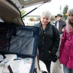 Kyle Jensen / The Record South Whidbey volunteers Marti Bauer (left) and Linda Jacobson (right) take a look at one of the 16 bags the volunteers will take on their aid trip to Haiti.