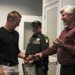 Tony Hartman (right) gives Eric Vasilyev (left) the belt that was used as a makeshift tourniquet to slow blood flow to his injured arm.