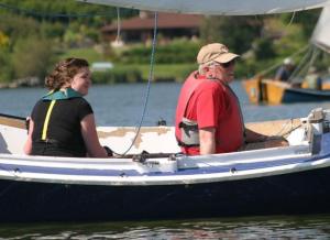 Camille Sasson and Bill Brown watch the horizon as they sail on Lone Lake. They check the wind and prepare for the weekly Pelican sailboat races sponsored by the South Whidbey Yacht Club.