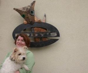 Harriet Behncke holds the living “Eddy” who inspired the name for the seven-month-old shop that sells T-shirts designed by local artists. The shop’s new sign