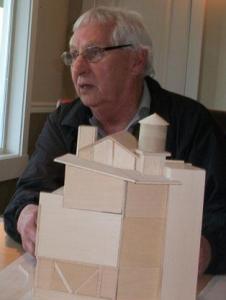 Paul Schell sits behind a model of a possible Boatyard Inn expansion project as he proposes his marina improvement ideas to the Port of South Whidbey commissioners.