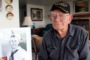 Herb Bacon poses next to a photo of himself as a serviceman in World War II. Bacon recently traveled to Washington D.C. to visit veterans memorials through the Honor Flight Network