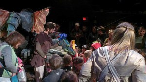 Children admire the mighty but timid dragon of Kenneth Grahame’s “The Reluctant Dragon