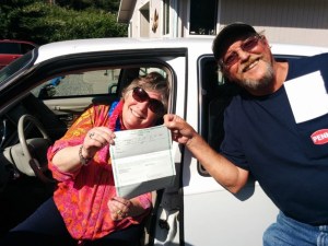 Gay Turn accepts the title and keys to her new car from Bobby Morrison. She won it in an Eagles raffle.