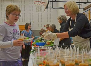 Kalea Staats and Margaret Nattress receive food from Margaret Andersen