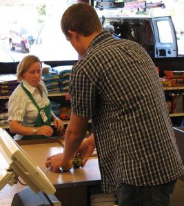 The Goose checker Belinda Parmenter from Freeland helps Seth Schoonover to learn the ropes on the day after the new Bayview grocery opened.