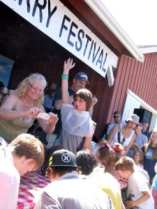 The winner of a pie-eating contest raises his hand in victory. The annual Loganberry Festival has been cancelled this year due to a scheduling conflict.