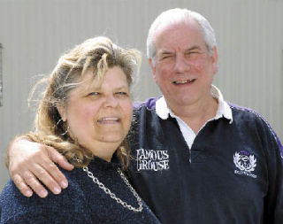 Maureen and Angus MacDonald stand where their house once stood. The house was burned during a string of arson fires last year.