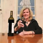 Kyle Jensen / The Record Longtime Langler resident and travel writer Sue Frause raises a glass on stage at Whidbey Island Center for the Arts, where Kitsch N&rsquo; Bitch is held.