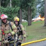Kyle Jensen / The Record South Whidbey firefighters William Piepenbrink (left) and Sean McDougald (right) return from the fire to hydrate.