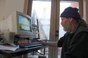 Kyle Jensen / The Record                                George Springer hops on the computer from which he operates Langley Community Radio. The radio station shares the same space as his side businesses, Whidbey Island Moped and RC Quadcopters.