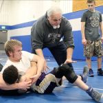 Evan Thompson / The Record                                South Whidbey senior Hunter Newman and his father, assistant coach Paul Newman, demonstrate a pinning move at a practice Monday afternoon.