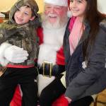 Contributed photo                                Santa poses with a couple of youngsters at a past Clinton Holiday Bazaar. Santa will return for free photos this year.