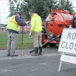Evan Thompson / The Record                                Two Langley public works employees use a tool to turn water back on for residents around Third Street following the fracture of a water main line. Residents in the area will be without water for a couple hours today as repairs are made to the pipe.