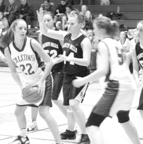 Falcon freshman Allison Wood protects the ball against a swarm of Granite Falls Tigers Friday night in Erikson Gym. Plagued by a tempest of turnovers