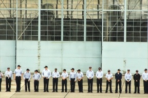 Sailors stand outside Hangar 5 at Naval Air Station Whidbey Island as they await the arrival of a charter jet carrying Chief Petty Officer Patrick L. Wade.
