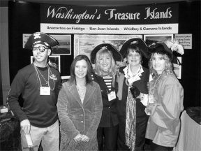 Tourism marketing coordinator RoseAnn Alspektor (center) teamed up with other regional tourism representatives to create a booth for the Governor's Tourism Summit. They created an island region theme: "Washington's Treasure Islands."