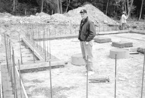 Hal Hallmer surveys the foundation poured on his new homesite on Haines Road Thursday. New construction like Hallmer’s house in Freeland