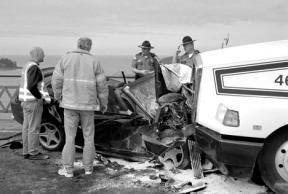 Washington State Patrol troopers and other emergency workers examine the car that struck a truck head-on May 2 on the Deception Pass Bridge. The collision