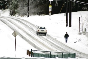 John Groce walks down Bayview Road Monday morning on his way to his car at the Bayview Park and Ride lot.