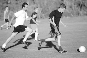 John Koska tries to chase down Tor Jones during Monday's pickup soccer game at the parks and recreation sports complex on Langley Road. Pickup games mix players of all age and experience levels.