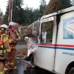 Kyle Jensen / The Record                                South Whidbey Fire/EMS Deputy Chiefs Wendy Moffatt and Jon Beck discuss the vehicle fire. The mail truck caught fire while on a regular delivery route.