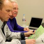 Kyle Jensen / The Record                                Commissioners Matt Simms (left) and Dennis Hunter (right) examine photos of the field damage taken Monday morning.