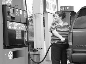 Carrie Lopez of Clinton pumps gas into her Oldsmobile Bravada at Short Stop Texaco in Freeland Monday. Lopez said she is trying to conserve gas by combining errands on one day