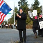 Justin Burnett / The Record &mdash;                                Coupeville resident Gary Piazzon waves the American flag during a protest in Freeland on Friday of the inauguration of President Donald Trump.