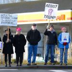 Justin Burnett / The Record &mdash;                                 Protesters waves signs opposing President Donald Trump on the corner of Fish Road and Highway 525 in Freeland on Friday. More than 60 people attended the event.