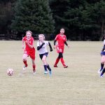 Contributed photo &mdash; The South Whidbey Reign U-14 girls, wearing white, beat Issaquah Select FC 3-1 at South Whidbey Sports Complex. Makenna Wicher, left, dribbles the ball on a break away as Kelly Murnane (right) provides an option.