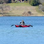 Justin Burnett / The Record &mdash; A fisherman paddles across Lone Lake on Monday afternoon. Bow fisherman will come to the lake in April to reduce a grass carp population that has reduced submerged plant communities and increased algae bloom.