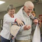 Evan Thompson / The Record &mdash; Ron Wadsworth, a 93-year-old Marine Corps veteran, receives a quilt from Quilts for Veterans coordinator Anita Smith. Wadsworth was one of nearly two dozen other veterans to receive quilts in gratitude of their service on Thursday at Maple Ridge Retirement and Assisted Living Community in Freeland.
