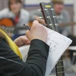 Evan Thompson / The Record &mdash; Paraprofessional Lori Chiarizio writes notes onto her music sheet at a practice session on March 7 inside South Whidbey Elementary School&rsquo;s music room.