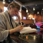 Kyle Jensen / The Record &mdash; Mary Anne Radmacher jots down thoughts at WiFire Coffee Bar, a place where she can typically be found working.